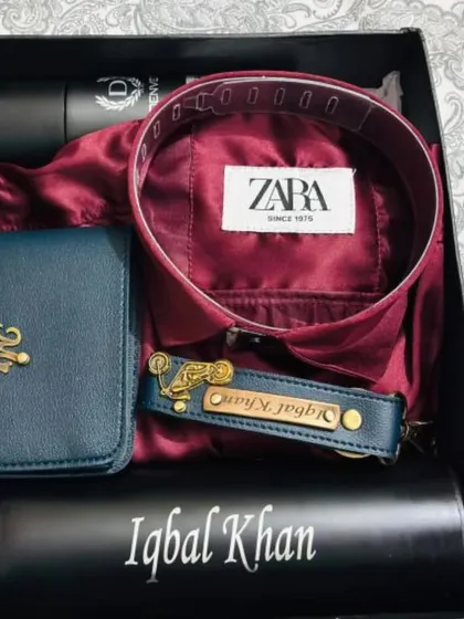 This stylish gift hamper features a rich maroon shirt paired with a personalized blue wallet, a matching keychain, a name-engraved temperature bottle, and deodorant.