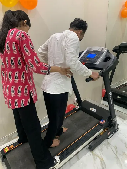 Here, I am guiding a patient through gait training on the treadmill. This is a crucial part of rehabilitation for many lower back and leg injuries, helping to restore correct movement patterns, build strength, and regain confidence with every step.