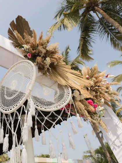 An elegant arch detail, combining white dreamcatchers with pampas grass and dried palm leaves for a perfect boho-chic aesthetic.