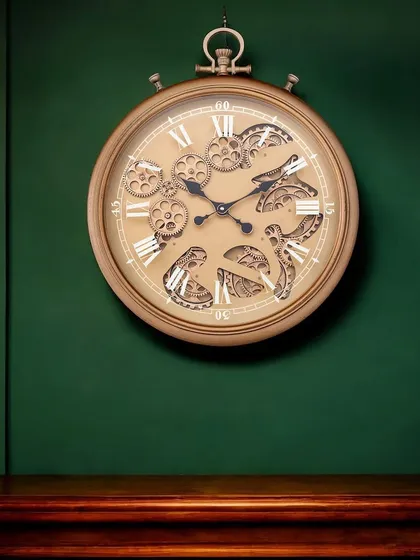 Our designer wall clock in an antique gold finish, shown here against a rich green wall. The brass design and moving gears create a perfect piece for a classic or traditional home.