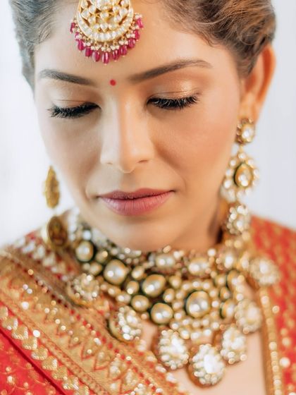 A detailed close-up of the wedding makeup, showing the soft shimmer on the eyelids and the flawless skin finish. Every detail is crafted to be beautiful both in person and in photos.