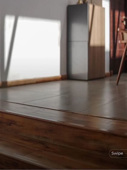 A detail of the split-level transition, showing the seamless flow between the wooden stairs and the tiled floor of the upper level.