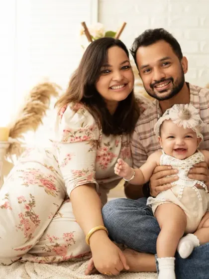 A happy family celebrating their baby girl's half-birthday milestone. Our studio provides a warm, bohemian-inspired setting with pampas grass for relaxed and joyful family portraits.