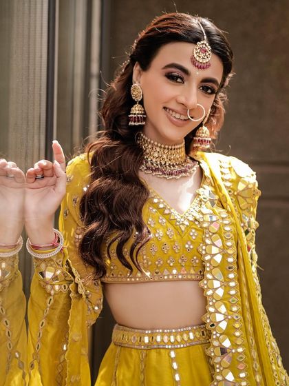 A bright and happy portrait of the bride, her smile and pose full of life and excitement for her Mehendi function.