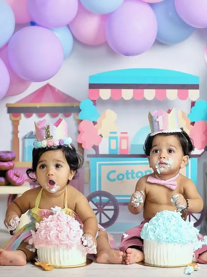 A candid moment from a twin cake smash session. With cake on their faces and hands, these two are having the best time celebrating their first birthday together.