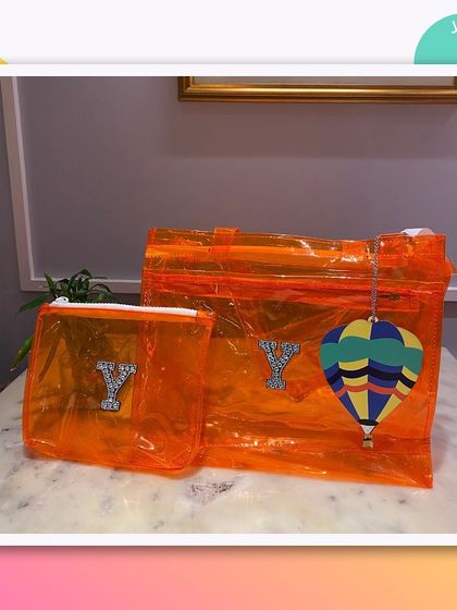 This orange jelly tote and pouch set is personalised with a 'Y' and a hot air balloon charm.