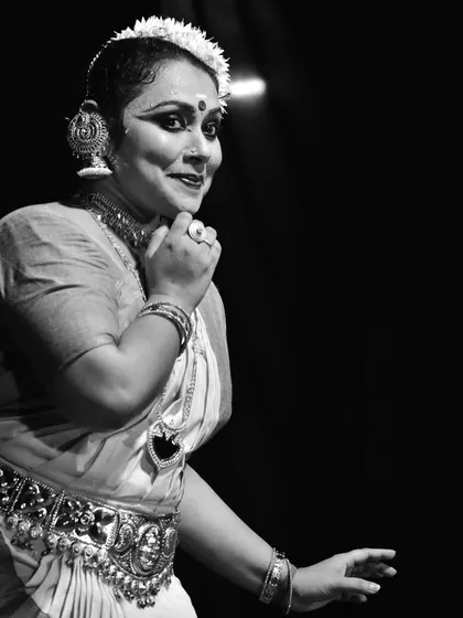 A black and white portrait from a performance, focusing on the subtle smile and emotive power of the dancer's expression.