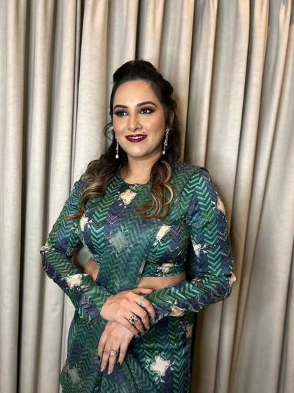 A sophisticated look for a wedding guest. The makeup is glamorous with a bold lip, and the printed saree adds a modern, fashionable touch.