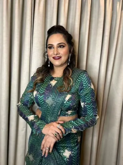A sophisticated look for a wedding guest. The makeup is glamorous with a bold lip, and the printed saree adds a modern, fashionable touch.