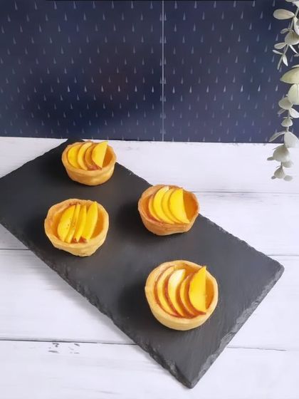 From our Monsoon Fiesta collection, these mini mango tarts are a perfect bite of sunshine on a rainy day, served elegantly on a slate platter.