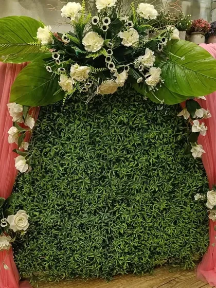 This elegant ready-made piece combines a classic green wall with soft pink drapes and white flowers for a gentle, romantic feel.