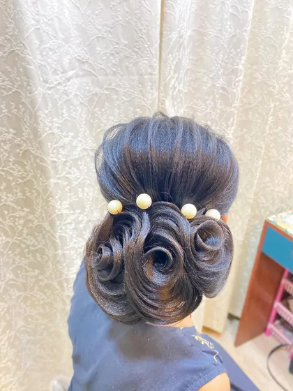 A clean and polished view of the rose and pearl bun. This hairstyle is very secure and will hold its shape throughout a long day of wedding festivities.