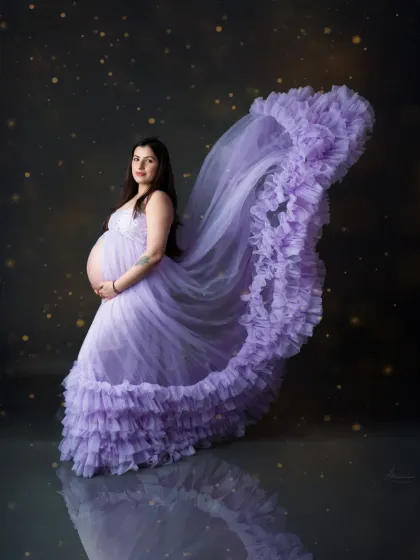 For a touch of magic, we love playing with fabric and light. This flowing lavender gown creates a dreamy, ethereal effect, making for a truly show-stopping solo maternity portrait.