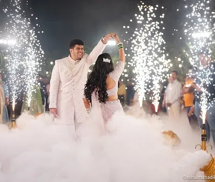 A beautiful shot of the couple dancing, surrounded by smoke and sparklers, creating a fairytale-like atmosphere.