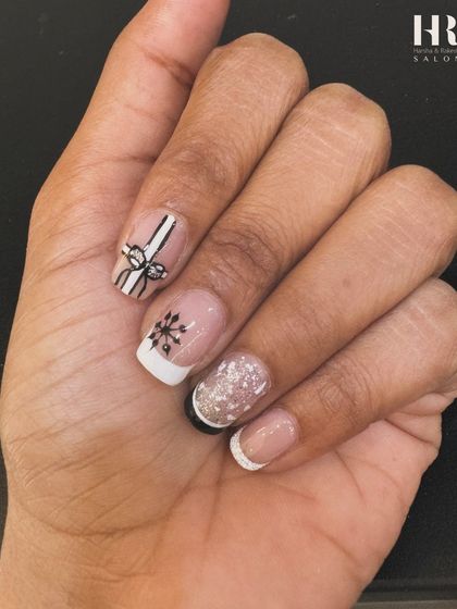 A minimalist take on festive nails. This design features a clean French manicure with subtle, hand-painted Christmas details like a gift bow and a snowflake for a touch of holiday cheer.
