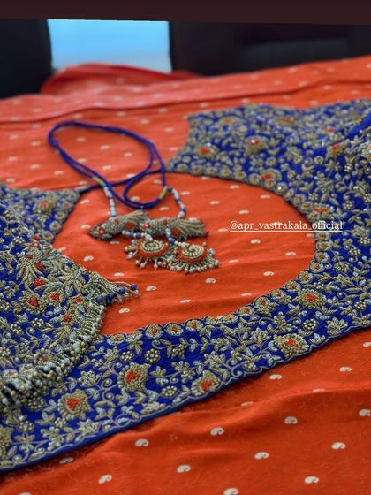 A royal blue blouse with heavy floral embroidery in silver and orange.