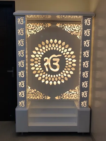 A beautifully crafted mandir we designed, finished in white with intricate 'Ek Onkar' jali work. The backlighting creates a serene and divine ambiance, making it a peaceful corner in the home.