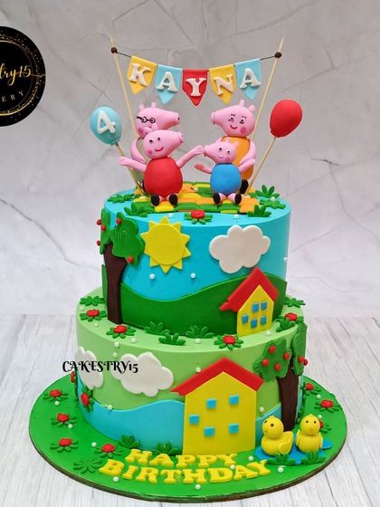 A delightful two-tier Peppa Pig themed cake for a 4th birthday. The design recreates Peppa's world with green hills, a house, and the whole Pig family in fondant.