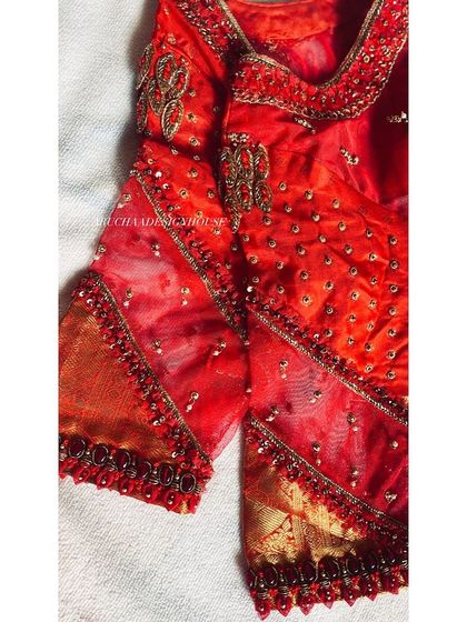 Gearing up for the wedding season with this fiery red blouse. It features a mix of sheer fabric and intricate beadwork, creating a glamorous and modern design.