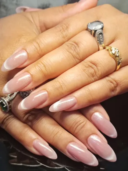 A soft and elegant manicure with a sheer, shimmery polish and a subtle white tip.