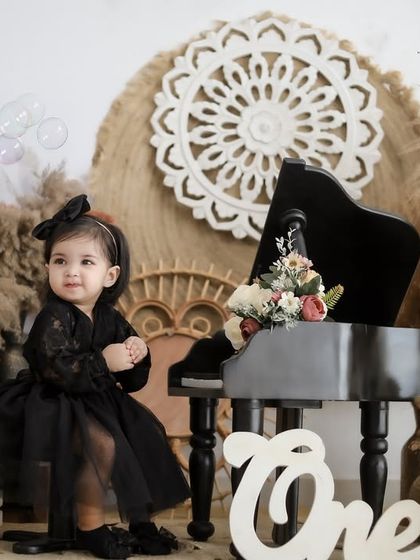 Capturing a moment of wonder as bubbles float by during a first birthday photoshoot. The soft lighting and boho elements add a touch of magic to the scene.