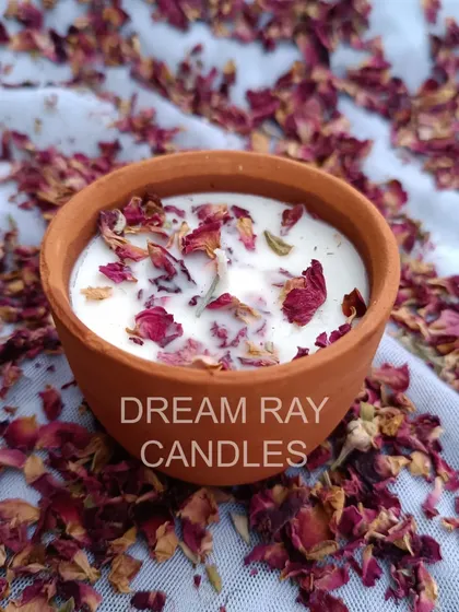 I create candles in various containers, including these rustic terracotta jars. Pictured is a rose-scented soy candle topped with dried rose petals, combining natural aesthetics with beautiful aromatherapy.