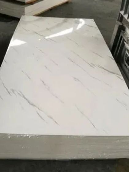 A stack of our PVC marble sheets, showing the clean, glossy finish and realistic white marble pattern.
