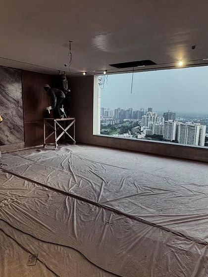 The interior of a penthouse apartment during the finishing stages. The design is coming together, perfectly complementing the expansive view of the city skyline.