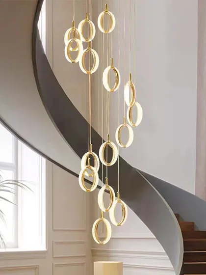 A full view of the cascading ring pendants installed in a grand, curved staircase, showcasing how lighting can become architectural art.