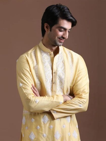 A soft yellow kurta with elegant white embroidery on the placket and body. This is a subtle, sophisticated option for any festive occasion.