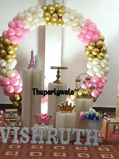 A classic pink, white, and gold balloon ring with "BABY" blocks. This is a timeless and beautiful choice for a girl's first birthday.