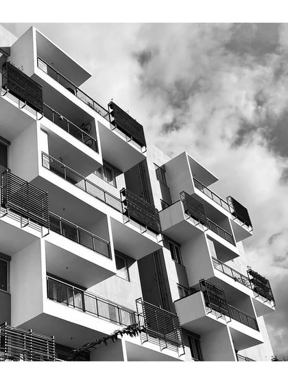 A black-and-white photograph of "The Treehouse" balconies emphasizes their geometric rhythm and texture. The design provides each apartment with a private outdoor space.