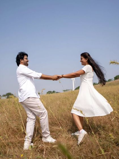 A joyful, twirling shot in a field, capturing the carefree spirit of love during a pre-wedding session.