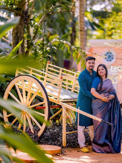 A happy couple poses with the rustic bullock cart prop.