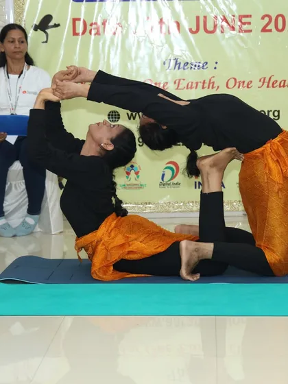 A partner-assisted Ustrasana (Camel Pose), showing how two people can work together to achieve a deeper backbend.