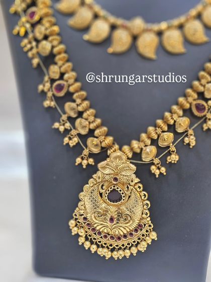 This long haar features a beautiful antique pendant, adding a touch of heritage to the overall bridal ensemble.