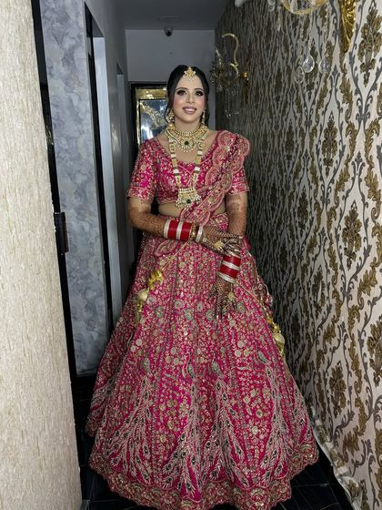 A full-length view of the bride in her magnificent pink lehenga. She looks every bit the royal princess on her wedding day.
