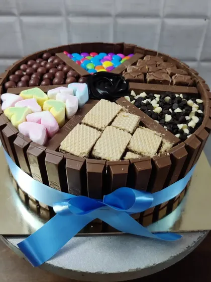 The ultimate chocolate lover's dream, my KitKat overload cake. This creation is packed with different treats in each section, including marshmallows, wafers, chocolate chips, and gems.