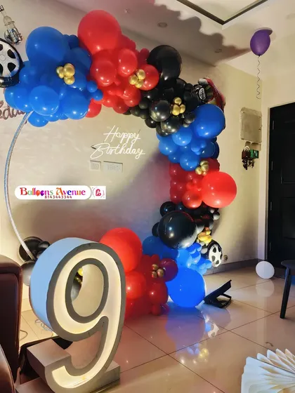 A close-up of the race car themed balloon arch, showing the vibrant colors and wheel accents.