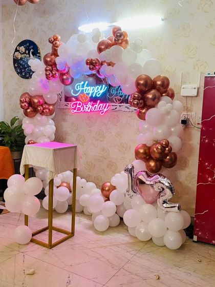 A wider view of the rose gold and white balloon ring setup at home. It shows how the decoration can transform a simple room into a beautiful party space.