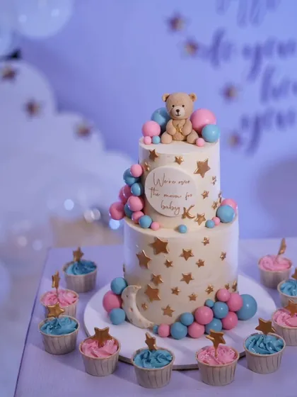 A beautiful "Twinkle Twinkle Little Star" themed baby shower cake for actress Drashti Dhami. The two-tier cake is decorated with pink and blue balloons, stars, and a teddy bear.