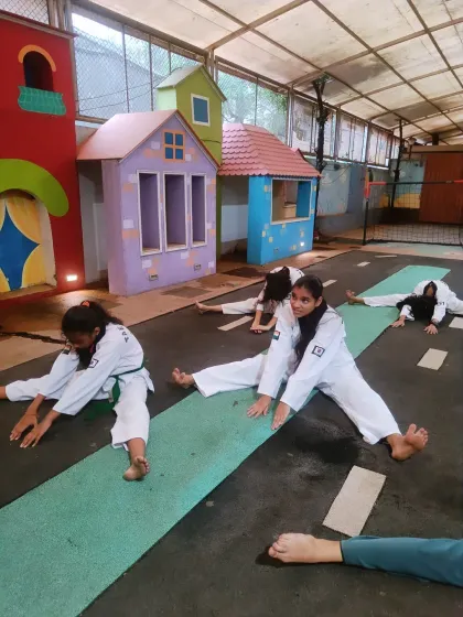 Our students work on their center splits, a challenging stretch that greatly improves hip flexibility. This is a fundamental part of our warm-up and cool-down routines.