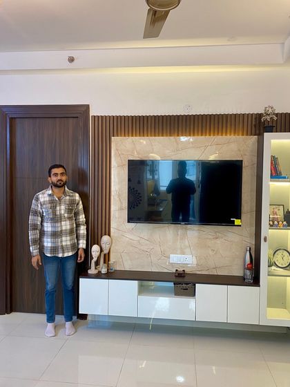 Presenting a completed TV unit with a beige marble-finish back panel, fluted wood accents, and a white console.