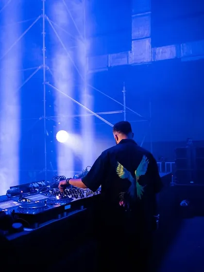 A shot from behind me on a massive stage, bathed in blue light. This captures the scale and atmosphere of a large indoor event.