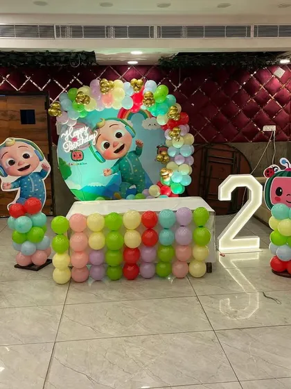 This Cocomelon setup for a second birthday shows how we can arrange character standees and a balloon-decorated cake table to create a fun and interactive space for kids.