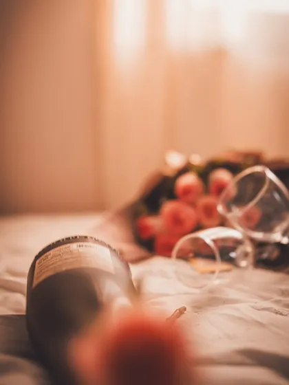 An artistic, blurry shot of the wine bottle and roses, creating a dreamy, memory-like effect.