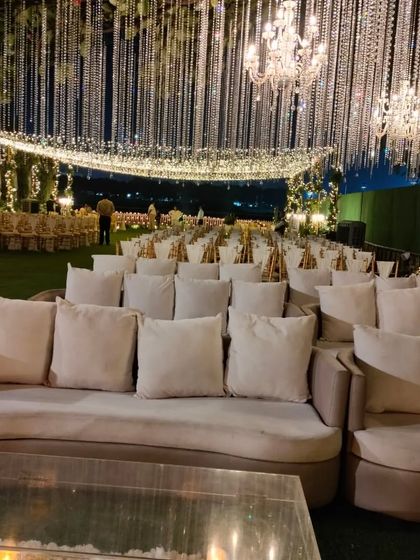 For a grand reception, I designed this lounge area with plush, curved sofas under a spectacular ceiling of cascading crystal strings and chandeliers. The look is one of pure opulence and glamour.