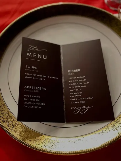 An elegant, minimalist menu card placed on a dinner plate. This simple yet sophisticated presentation adds a touch of class to a sit down dinner reception.