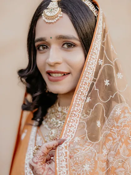 A close-up portrait of the bride, her eyes sparkling. The delicate veil frames her face beautifully, creating a soft and romantic feel.