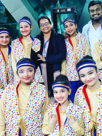 With a group of young performers in colorful dotted costumes. I ensure costumes are vibrant, comfortable, and suitable for the children.